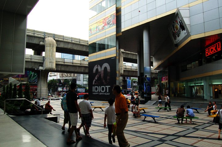 A Bangkok street beneath the skytrain, an advertising panel altered to read IDIOT