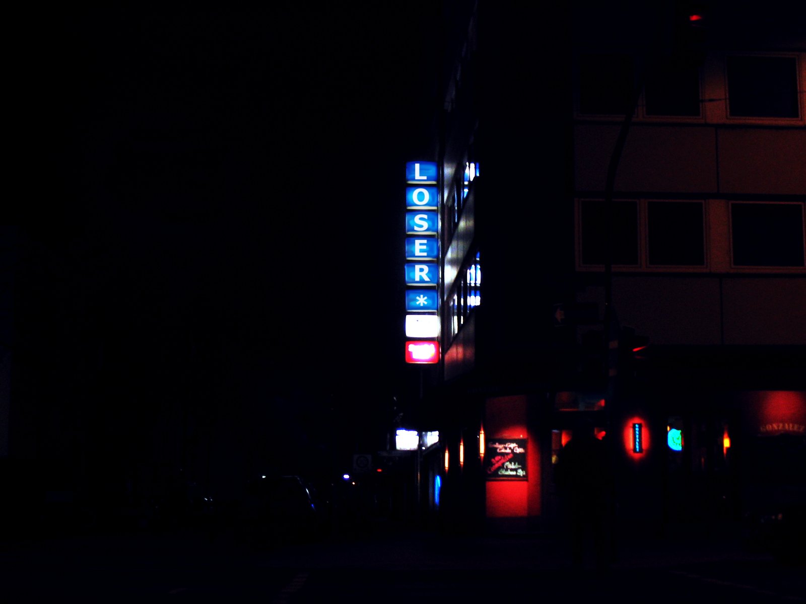 Cologne at night — a red neon sign reading LOSER